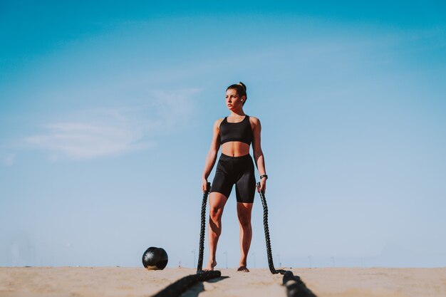 Functional training workout on the beach, fit and athletic woman doing sport outdoors