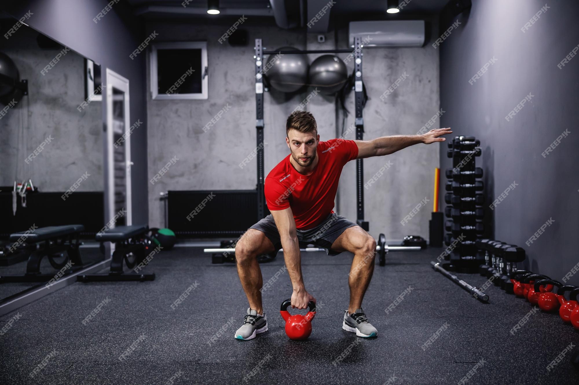 Functionele fullbody met een kettlebell een man in een rood | Premium Foto