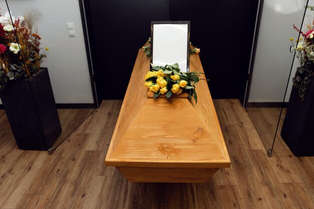 Photo funeral concept flowers on the coffin and an empty photo frame overall plan bereavement