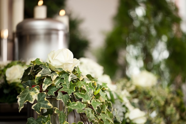 funeral urn with candles and flowers