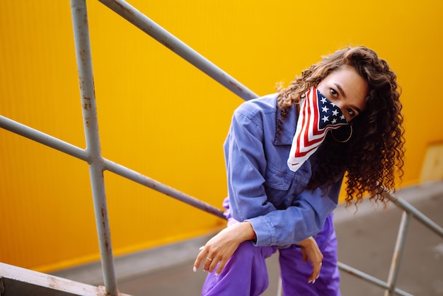 Funky jonge vrouw met Amerikaanse bandana die alleen op straat danst Sportdansen en stedelijke cultuur