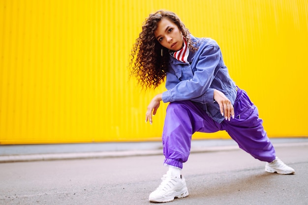 Photo funky young woman with american bandana dancing alone in the streetsport dancing and urban culture