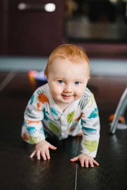 Funny baby boy crawling on the floor in nursery room at home Baby health care and family concept