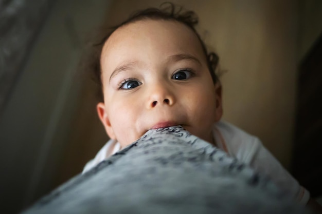 Funny baby boy playing with mom Toddler looks to his mom