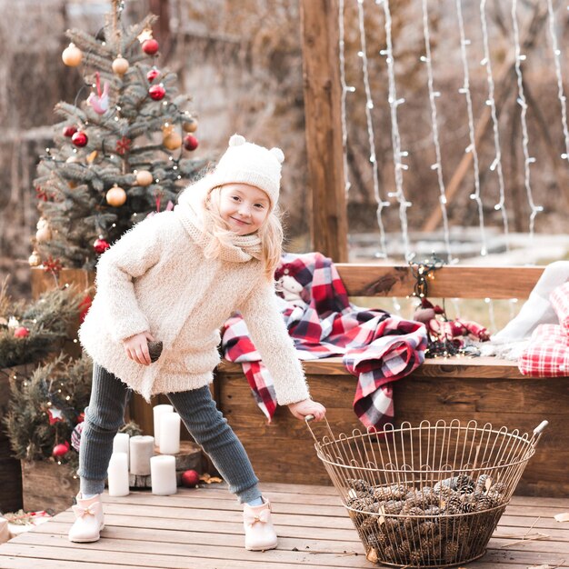 屋外でクリスマスの装飾で遊ぶ面白い女の赤ちゃん