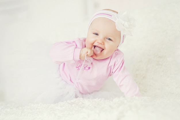 Funny baby shows tongue looking at camera