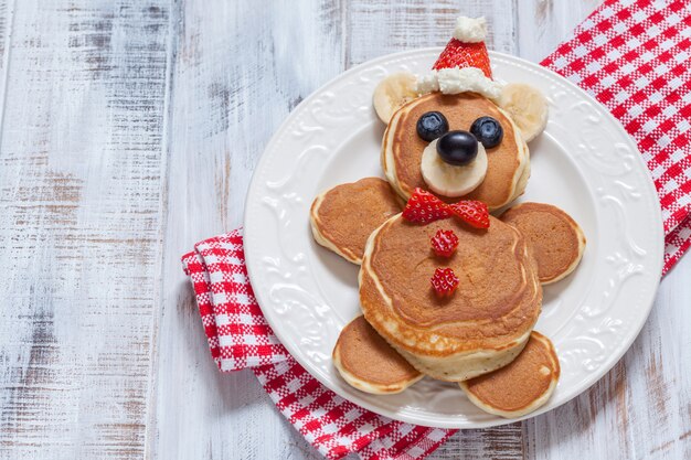 Funny bear pancakes with berries for breakfast