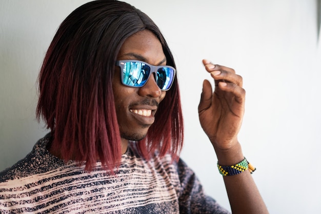 Funny black boy with long hair and sunglasses laughing