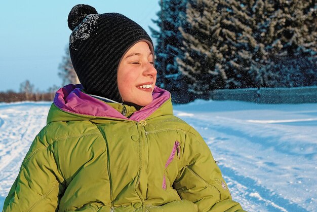 Funny boy on a Sunny winter day laughing on the street