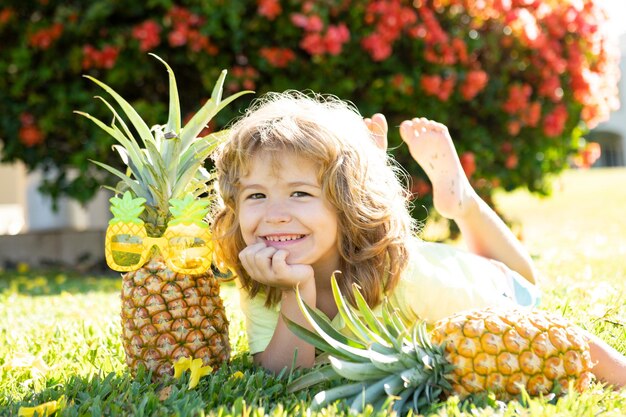 Ragazzo divertente con ananas, primo piano faccia dei bambini.