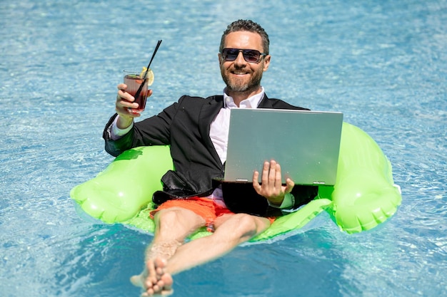 Funny business man in a business suit floating in the water in the pool remote work crazy freelancer