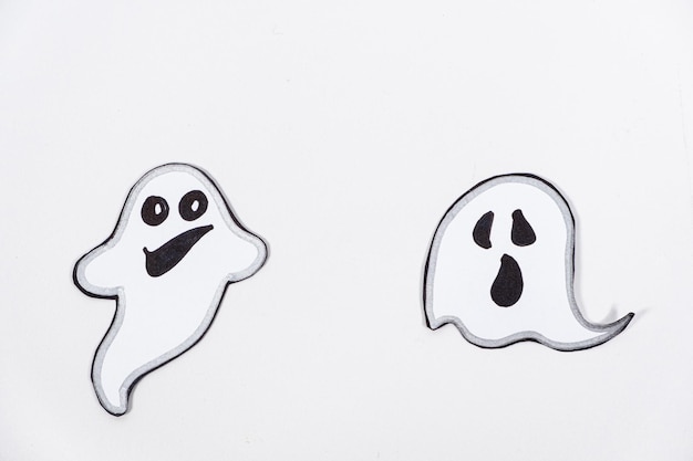 Photo funny charming ghosts with faces on a white background top view