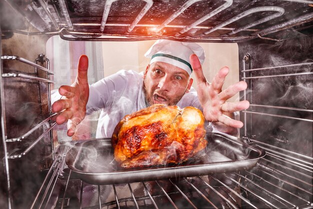 Funny chef overlooked roast chicken in the oven, so she had scorched, view from the inside of the oven. Cook perplexed and angry. Loser is destiny!