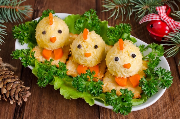 Funny chickens on the Christmas table with the symbol of 2017. Snack of cheese and almonds