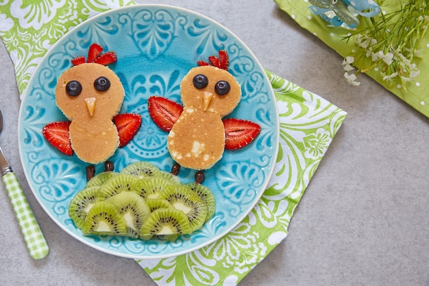 Funny chickens pancakes with berries for kids breakfast