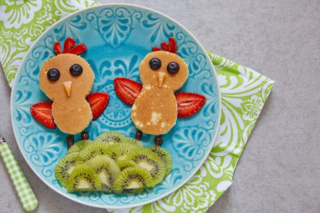 Funny chickens pancakes with berries for kids breakfast