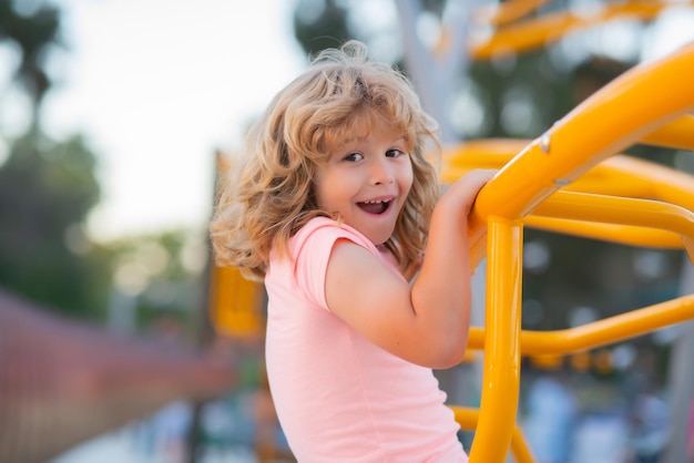 Funny child boy plays on playground kid climbing on playground