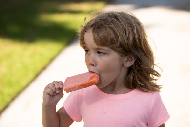 Funny child eating ice cream, face. Kids head portrait.