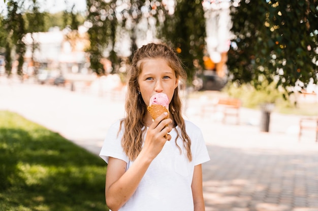 Funny child girl eating ice cream cone in waffle cup Creative advert for ice cream stand and shop