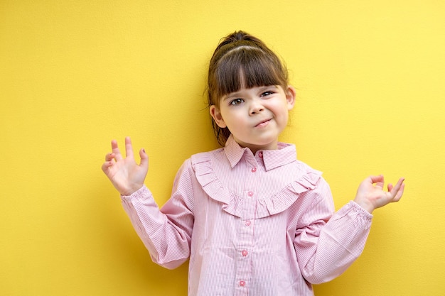 Funny child girl making face adorable child have fun in joy caucasian kid in pink blouse posing with...