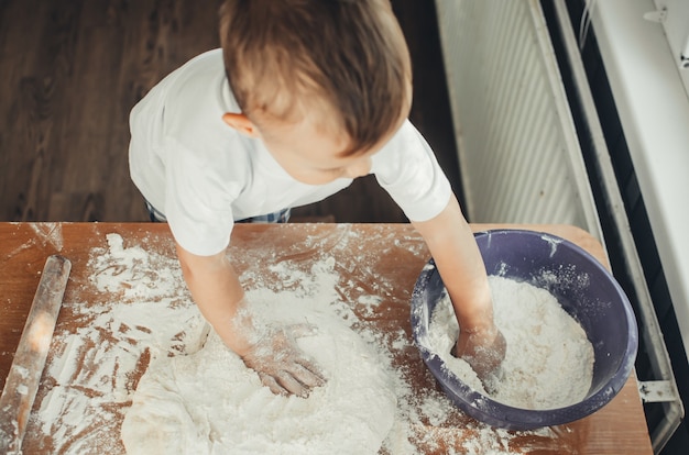 Funny child girl preparing cookies, lifestyle, real nordic interior, rustic style, the brown and red wood background