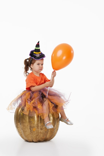 Funny child girl in witch costume for Halloween on white