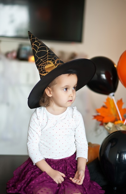 Funny child girl in witch costume for Halloween