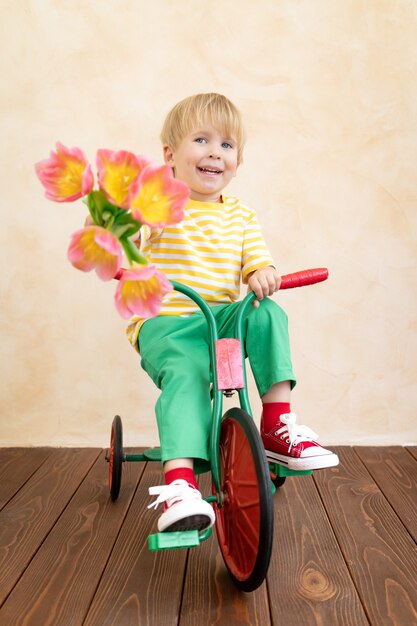 Funny child holding bouquet of flowers.