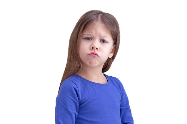 Funny child kid making face isolated on white background looking at camera waist up caucasian little girl of 5 years in blue