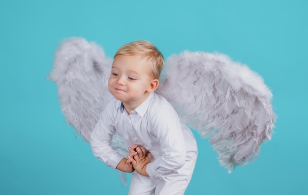 Foto bambino divertente che indossa ali d'angelo con un'espressione felice di sorriso divertente