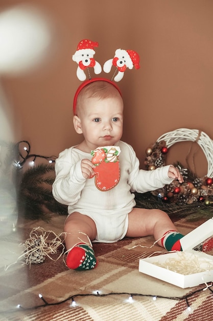 Funny child wearing in a Christmas suit near Christmas tree in room