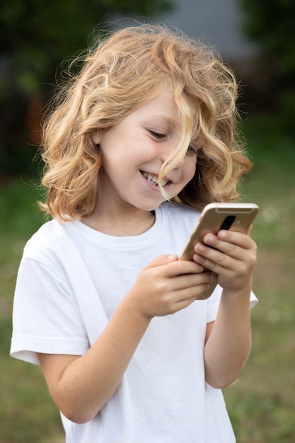 Funny child with long hair holding a mobile 