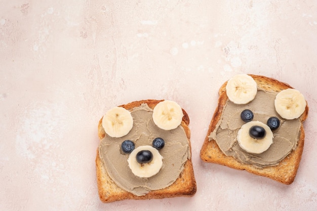 Funny children bear toasts with nuts butters for breakfast