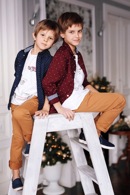 Funny children next to the  Christmas tree having fun together