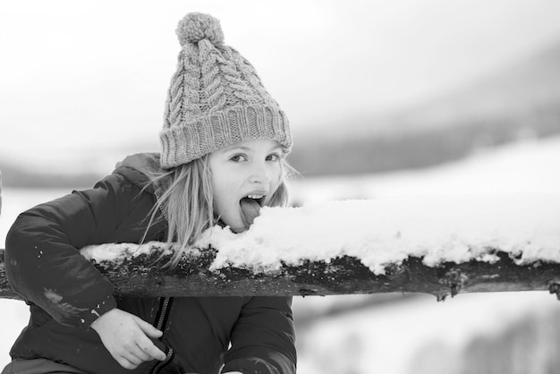 Funny children eat snowflakes child lick and eating snow in winter children with snow flakes comical