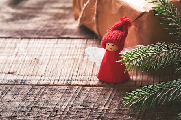 Funny Christmas Angel fir tree branches and gift boxes on winter snowy background with snowy branches. Christmas or Winter concept.