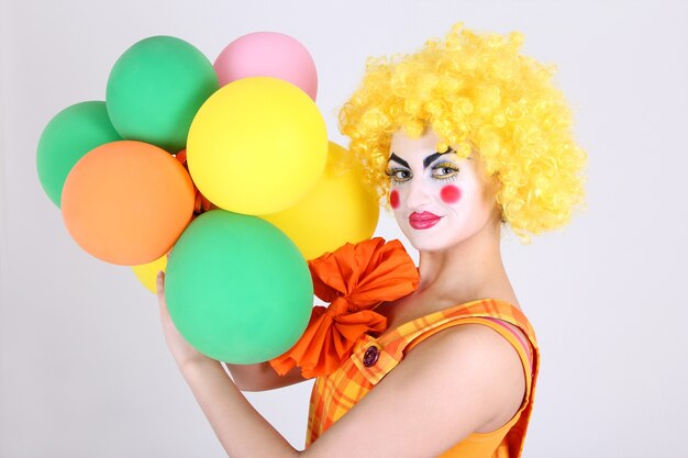 Funny clown in costume with colourful balloons