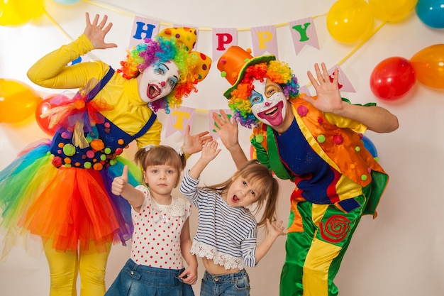 Веселые клоуны на празднике демонстрируют свои хорошие эмоции с девушкой