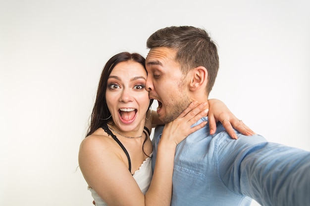 Funny couple taking selfie photo, isolated studio shot