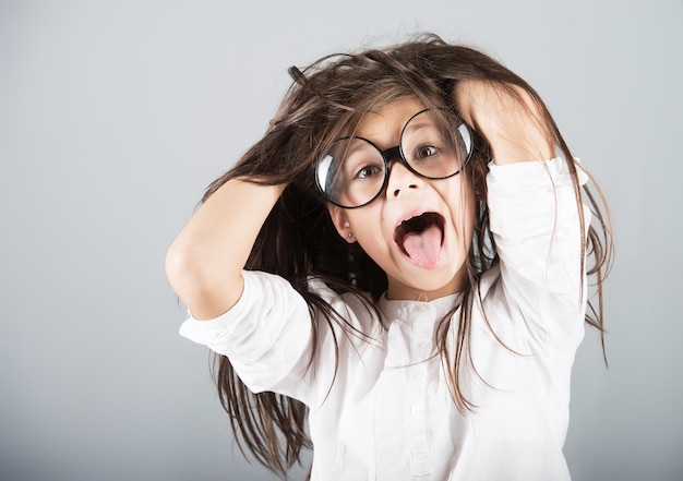 Funny crazy girl studio shot gray background