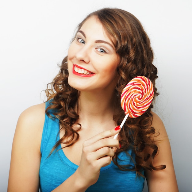 Funny curly woman  holding big lollipop.  