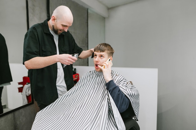 Funny customer cuts hair in a barrel and makes a phone call