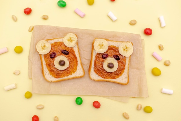 Funny cute bear faces sandwich toast bread with peanut butter banananuts marshmallow Kids childrens baby's sweet dessert healthy breakfast lunch food art on plateclose uptop view