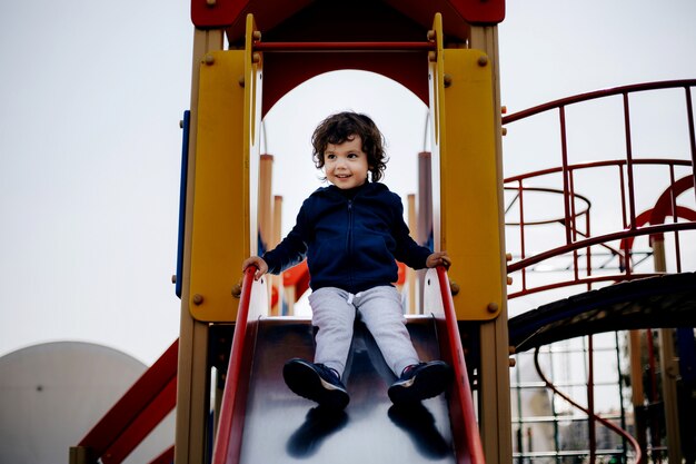 Funny cute happy baby playing on the playground. The emotion of happiness, fun, joy. Smile of a child.