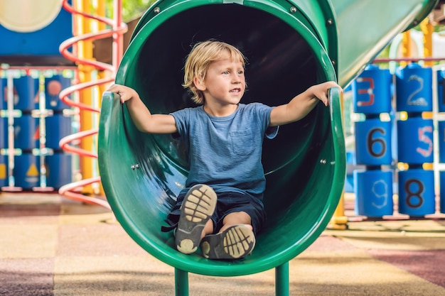 Funny cute happy baby playing on the playground. The emotion of happiness, fun, joy.