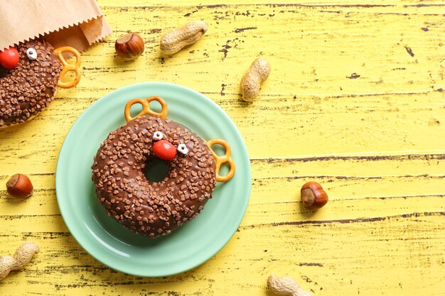 Funny decorated donut on plate