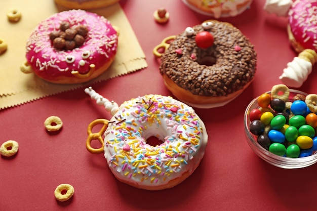 Funny decorated donuts on table