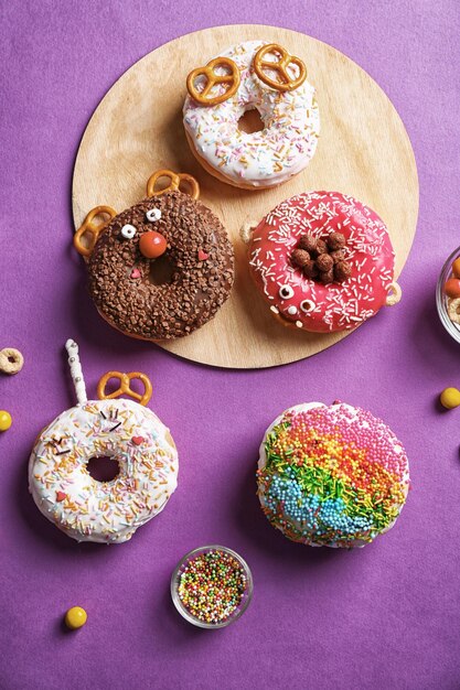 Funny decorated donuts on table