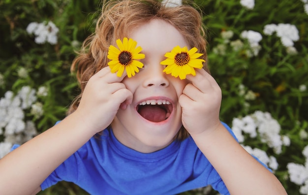 Забавный мечтательный малыш, гуляющий в цветущем весеннем саду