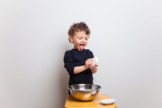 Funny emotional baby dabbles, washes his hands with soap and shows tongue.